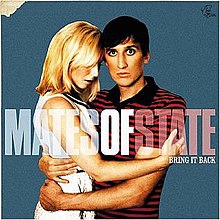 The cover features a blond-haired woman wearing a white dress hugging a black-haired man wearing a black-and-red striped shirt against a teal background. The band's name appears over them, with "Mates" and "State" being see through. The album title is below "State", colored in white.