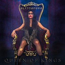 The cover artwork for "Queen of Kings". The artwork features Alessandra in torn fishnet stockings, a black shirt, and a scarf sitting on a throne amongst a blue and purple background.