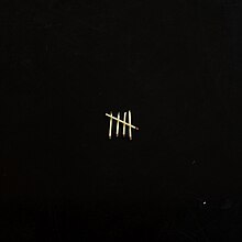 A black cover with a scratchy five match sticks in the shape of hatch marks on it