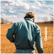 Hunt with his back to the camera in a field.