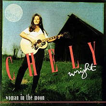 A picture of a woman playing an acoustic guitar in a grassy field, with a barn and full moon behind her. The text "Chely" spans the center of the image in large red letters, with the text "Wright" under it in white cursive. Text reading "woman in the moon" in all lowercase is present at the bottom left.