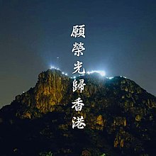 An image of Lion Rock at night with lights glowing from a distance. The song's title is read in Chinese characters virtually.